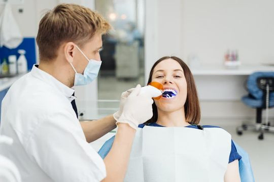 dentista realizando blanqueamiento dental