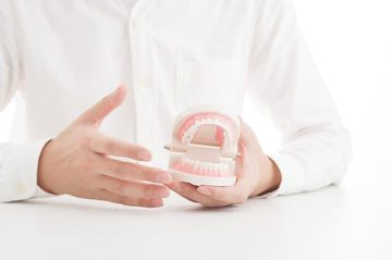 dentista mostrando una dentadura